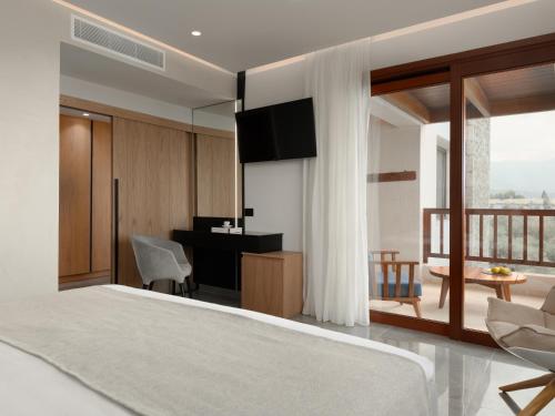 a bedroom with a bed and a desk and a room at Ikaros Beach, Luxury Resort & Spa - Adults Only in Malia
