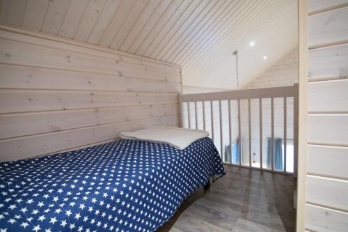 a bedroom with a blue and white bed in a room at Ettomies II in Äkäslompolo