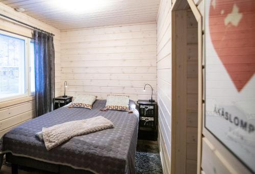 a bedroom with a bed with two pillows on it at Ettomies II in Äkäslompolo