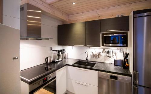 a kitchen with black and white counters and a sink at Ettomies II in Äkäslompolo