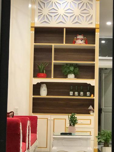 a book shelf with potted plants and a red chair at NEW CITY HOTEL in Tây Ninh
