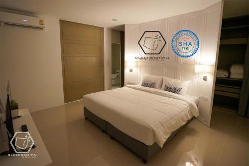 um quarto com uma cama e uma placa na parede em Sleepstation at Pratunam em Bangkok