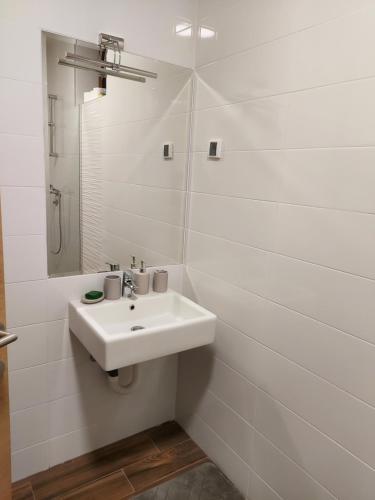 a white bathroom with a sink and a mirror at Apartman Grey in Zlatibor