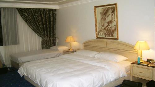 سرير أو أسرّة في غرفة في فندق الدار البيضاء مكة