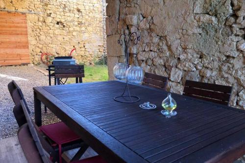 une table en bois avec deux verres à vin dessus dans l'établissement Maison gasconne au calme au cœur du Gers, à Duran