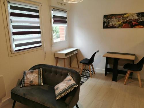 un salon avec un canapé et une table dans l'établissement Studio calme avec parking, à Saint-Pierre-du-Mont