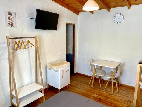 a living room with a table and a tv on a wall at Apart Las Carretas in El Calafate