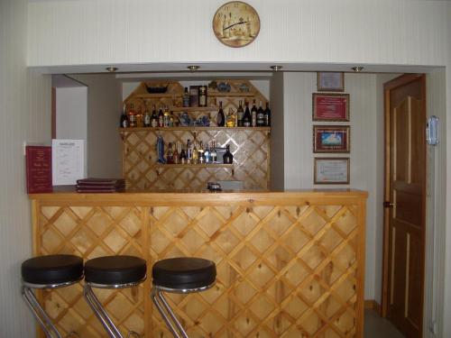 a bar with two stools in a room with alcohol at Гостиница ИЛЕК in Aktobe