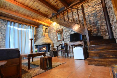 a living room with a staircase and a stone wall at Georgio's V Chalet Kalavrita in Kalavrita