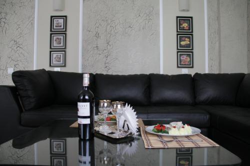 a bottle of wine sitting on a table next to a couch at Гостиница ИЛЕК in Aktobe