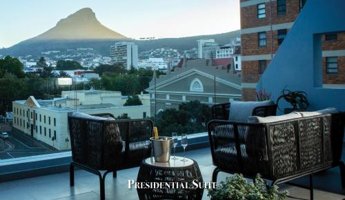 a balcony with chairs and a table with a view of a mountain at Labotessa Luxury Boutique Hotel in Cape Town