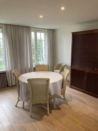 a dining room with a white table and chairs at House Zoute Stables 125sqm in 5 Ha property near seaside in Knokke in Knokke-Heist
