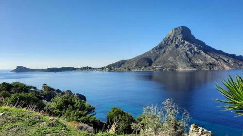 a view of crater lake with a mountain in the background at Avra Studios in Masouri