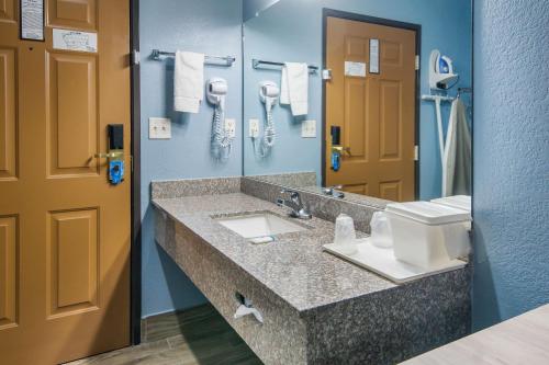 een badkamer met een wastafel en een spiegel bij Rodeway Inn Carrollton I-35E in Carrollton