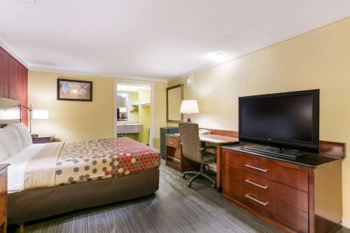 a hotel room with a bed and a desk and a television at Econo Lodge Frederick I-70 in Frederick