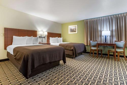 a hotel room with two beds and a table and chairs at Econo Lodge in Cherokee