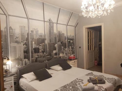 a bedroom with a large window of a city at B&B La Corte Dei Samidagi in Alessandria