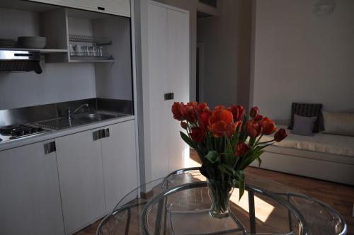 Lodges le Mura في فلورنسا: إناء من الزهور على طاولة زجاجية في مطبخ