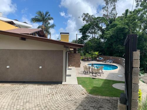 a backyard with a swimming pool and a house at Casa Ideal para Férias em Florianópolis in Florianópolis