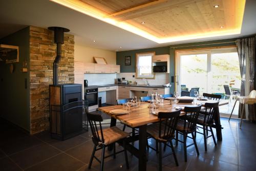 a kitchen and dining room with a wooden table and chairs at Le Domaine d'Emma : Le Golden in Soultzeren