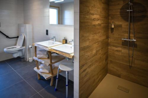 uma casa de banho com um lavatório e um WC em Le Domaine d'Emma : Le Golden em Soultzeren