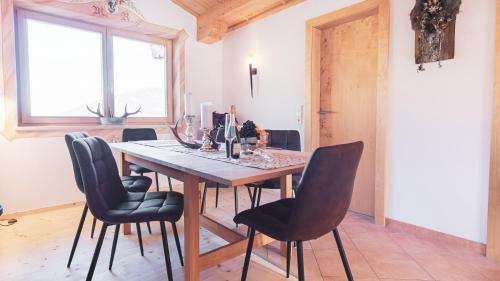 a dining room with a wooden table and chairs at Stubaier Bauern Appartement in Telfes im Stubai