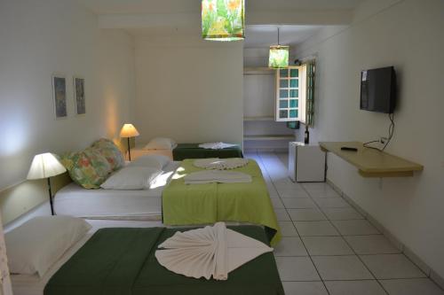 sala de estar con 2 camas y sofá en Capitania Praia Hotel Fazenda, en Porto Seguro