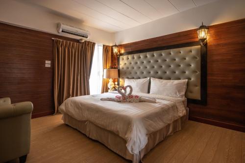 a bedroom with a large bed with a large headboard at @42 Residence in Bangkok