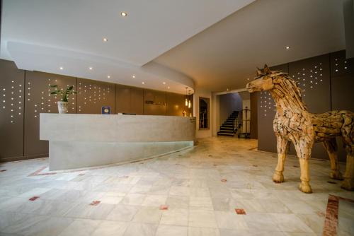 a statue of a giraffe standing in a lobby at Lingos Hotel in Florina