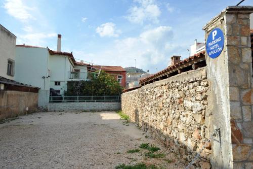 a stone wall with a blue sign on it at Apollon Hotel in Argos