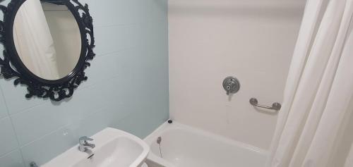 a bathroom with a toilet and a mirror on the wall at Hugo Beach Hotel & Apartments in Gandía