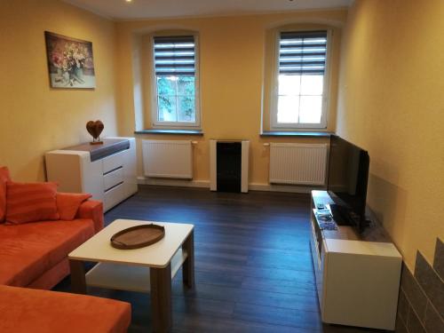a living room with a couch and a tv at Ferienwohnung Fam. Hähle in Burgstaedt