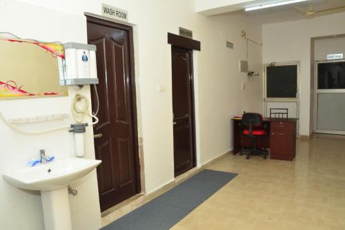 een ziekenhuiskamer met een wastafel en een deur bij Tranquil AC Budget Room( Single, Family & Group) in Bhubaneshwar