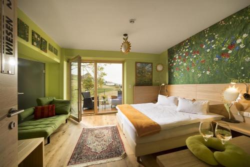 um quarto com uma cama grande e uma parede verde em Malerwinkl Restaurant + Kunsthotel em Hatzendorf