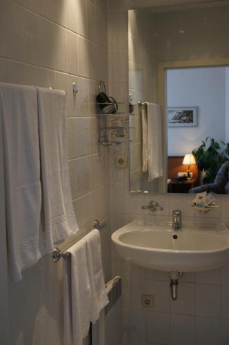 a white bathroom with a sink and a mirror at Hotel-Pension Seeblick in Kühlungsborn
