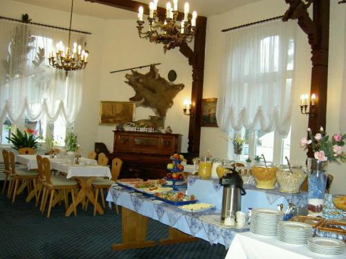 a dining room with tables and chairs and chandeliers at Hotel-Pension Seeblick in Kühlungsborn