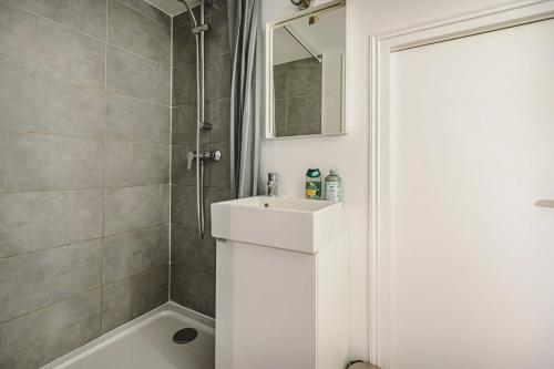 a white bathroom with a sink and a shower at Hyper centre - Cathédrale in Reims