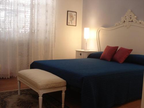 a bedroom with a blue bed with red pillows at Residenza Levante in Syracuse