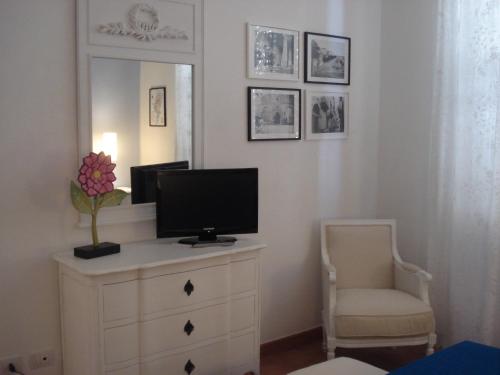 a room with a television on a dresser with a chair at Residenza Levante in Siracusa