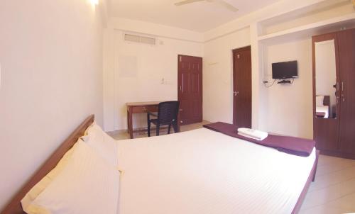 um quarto com uma cama, uma secretária e uma mesa em Noah's Ark em Cochin