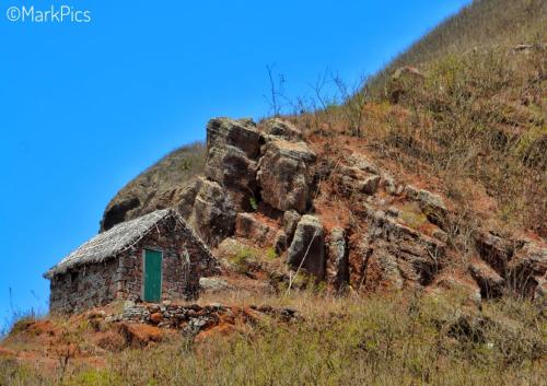 an old stone building with a green door on a hill at Black Mamba in Paul