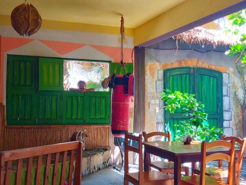 a dining room with green doors and a table and chairs at Black Mamba in Paul