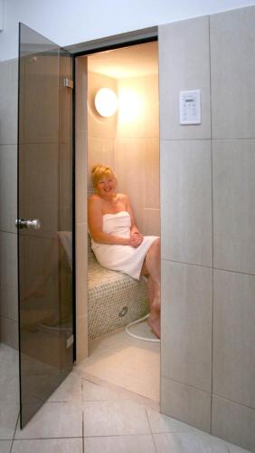 a woman sitting in a bath tub in a bathroom at Penzion Hubert Františkovy Lázně in Františkovy Lázně