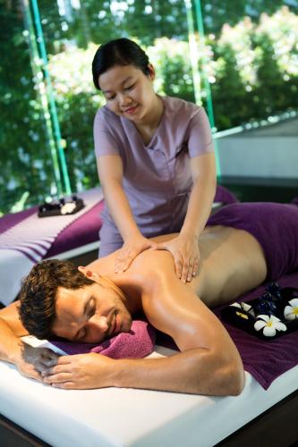 a woman is giving a man a massage on a bed at Naman Retreat in Da Nang