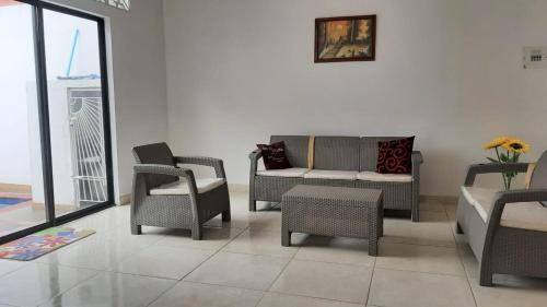 a living room with chairs and a couch and a table at Casa piscina in Mariquita
