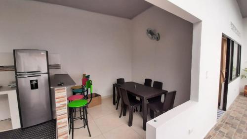 a small kitchen with a table and a refrigerator at Casa piscina in Mariquita