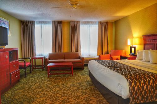 ein Hotelzimmer mit einem Bett und einem Wohnzimmer in der Unterkunft Baymont by Wyndham Grand Rapids N/Walker in Grand Rapids