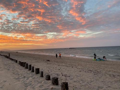 a group of people walking on the beach at sunset at Cabanadu Preá Kite in Prea