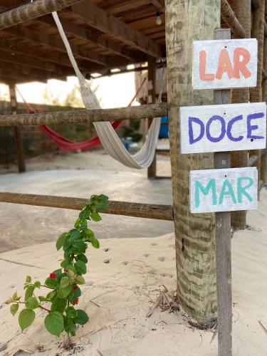 a sign on a pole on the beach with a dog mar sign at Cabanadu Preá Kite in Prea