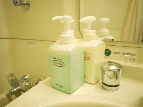 two bottles ofodorizers are sitting on a bathroom sink at Hotel Route-Inn Igaueno -Igaichinomiya Inter- in Iga